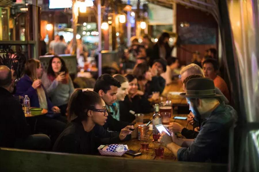 Gente comiendo en un comedor abarrotado en SoMa. San Francisco, California.