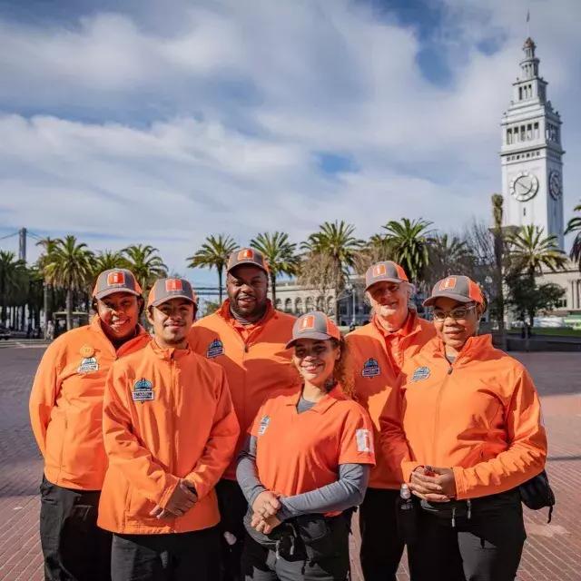 Os Embaixadores de Boas-Vindas de São Francisco se preparam para receber os visitantes no Ferry Building.